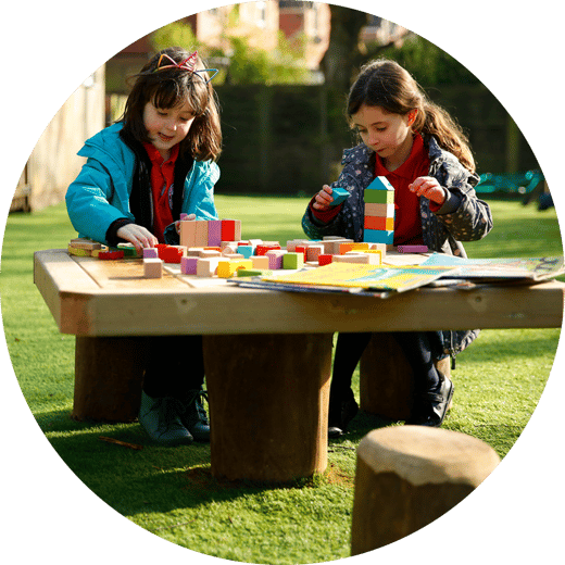 children playing with blocks on a wooden table
