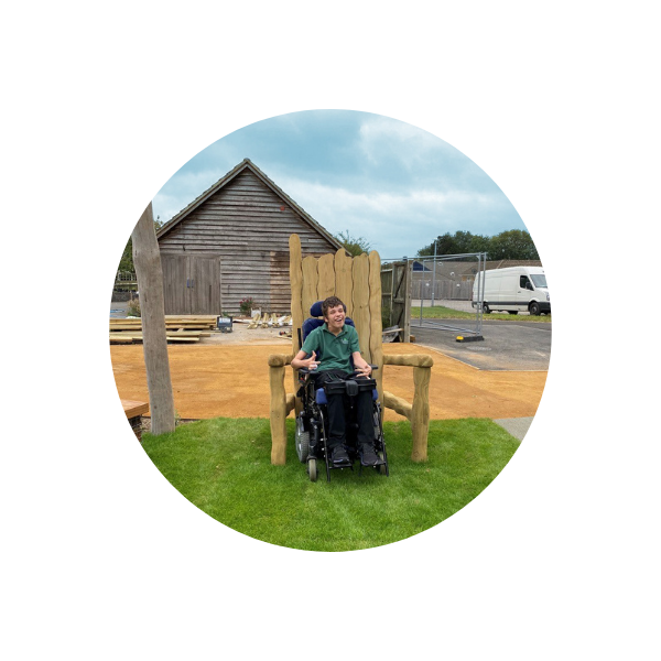 teenager in a wheelchair by a giant timber throne