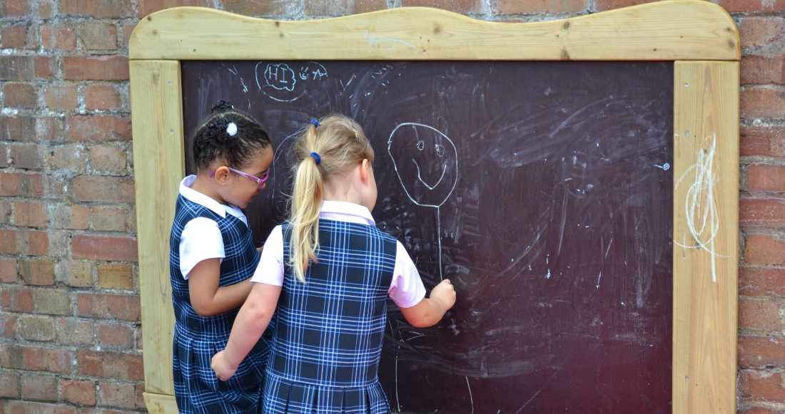 girls drawing on blackboard